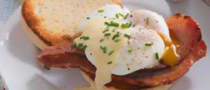 Mother's day breakfast, a bun with bacon and fried egg that has just been broken.